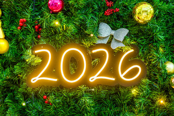 Obraz premium A festive arrangement of a Christmas tree with colorful ornaments and a glowing number 2026 in the center, symbolizing the upcoming New Year celebration.