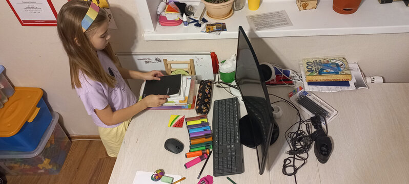 Young girl organizing school supplies on desk at home   - Powered by Adobe