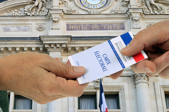 Vannes, France, 16 novembre 2025 : Concept d'&eacute;lection municipale fran&ccedil;aise avec une carte &eacute;lectorale en main tendue &agrave; une autre main et la fa&ccedil;ade d'une mairie
