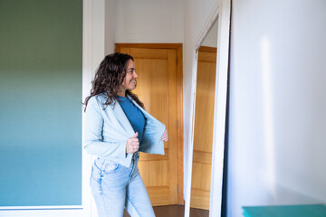 Woman trying on clothes looking at reflection in mirror