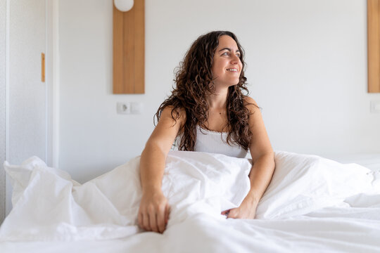 Woman waking up in bed, looking content