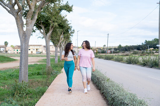 Two women friends walking and talking outdoors