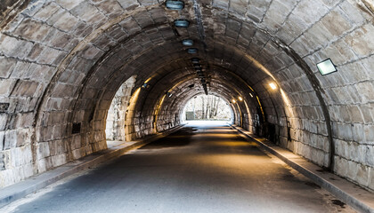 Obraz premium Historic Stone Arch Road Tunnel Interior Leading to Daylight