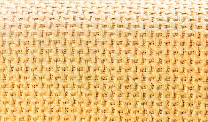 Abstract pattern of tan threads and criss-cross fabric weaving full frame