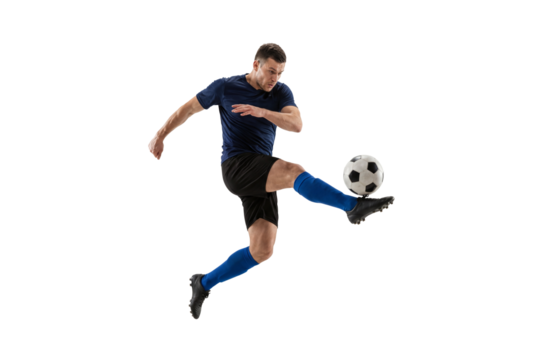 Male soccer player kicking ball in mid air on isolated black background, athletic action and competitive sport concept for training, fitness motivation and team game promotion