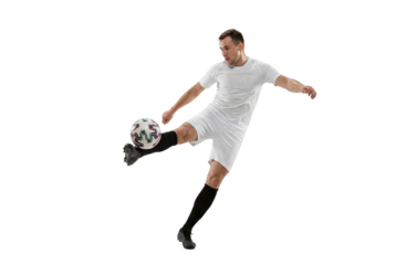 Male soccer player kicking ball in mid air on isolated background, athletic action and competitive sports concept for training, coaching materials and youth team promotion