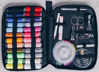 A Comprehensive Sewing Kit Featuring Spools of Thread, Needles, Scissors, and Essential Tools for Crafting and Repairing Fabrics