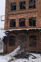 Lower floor of an abandoned brick factory with broken supports and snow-covered debris. Concept of structural decay, risk assessment, educational materials and urban studies.