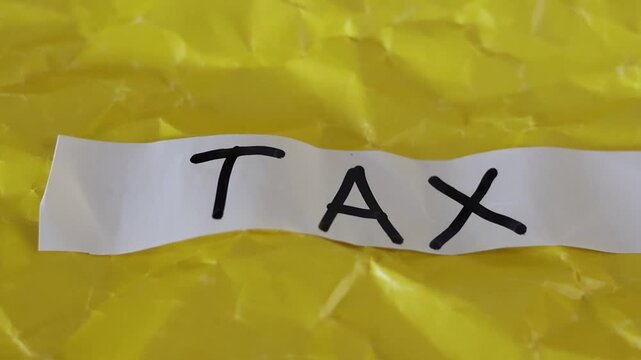 Un primer plano de un papel blanco con la palabra impuesto en un fondo amarillo