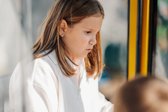 Young girl traveling thoughtfully in public transport bus - Powered by Adobe