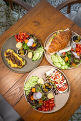 Healthy breakfast plates arranged on a rustic wooden table with fresh ingredients