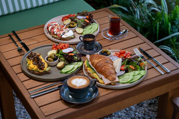 Healthy breakfast plates arranged on a rustic wooden table with fresh ingredients