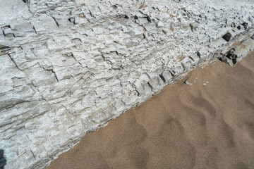 Layered rocks, flysch texture background. Sedimentary rock, striations stone pattern