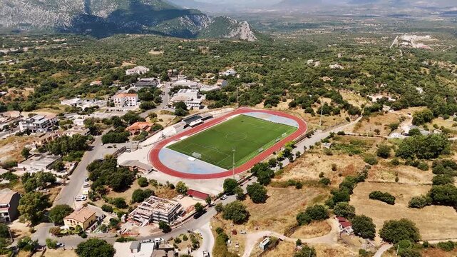 Aerial view of Dorgali football pitch surrounded by scenic Sardegna landscape