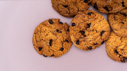 A collection of perfect dessert cookies, featuring delicious chocolate chips embedded in the golden dough, presented on a minimalist, clean white surface.
