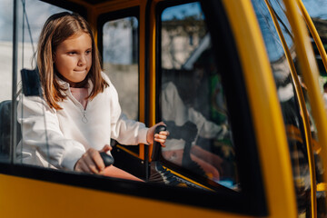 Little girl playing with a toy excavator outdoors