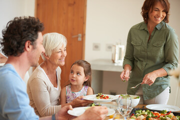 Smile, serving and love with family at lunch for bonding, nutrition and thanksgiving event. Grandmother, girl and social gathering with dad in home with parents, celebration and brunch or meal
