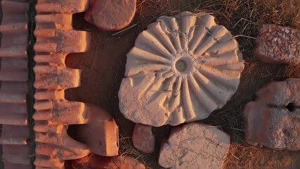 Ancient architectural decorative elements lying on the ground casting long shadows