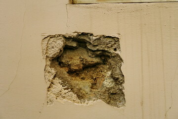 Mur trou&eacute; avec mortier et pierres apparentes.