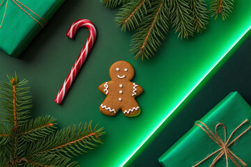 Vibrant Christmas festive flat lay with gingerbread man, candy cane, and fir branches on a green background with luminous accents, celebrating the holiday season
