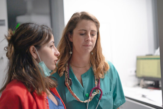 Doctor talking with patient in hospital corridor