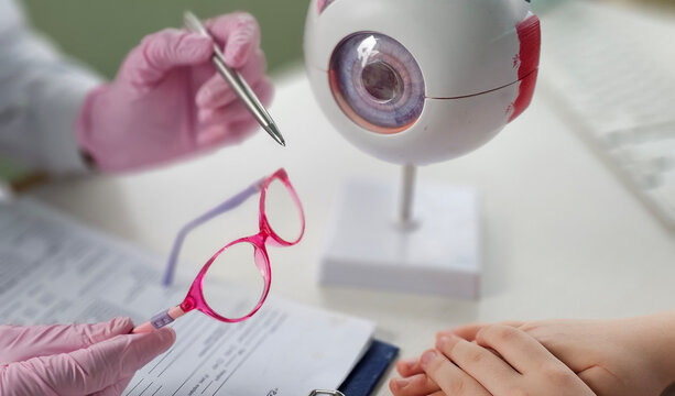 Eye examination with modern equipment showcasing colorful glasses and an eye model