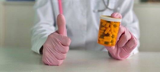 Doctor holding a prescription bottle with thumbs up gesture