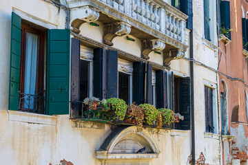 Aged Venetian facade with balcony and potted plants