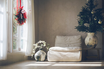 white sofa on the flor and vase with flower in room and decorate with christmas wreath hanging on bright window