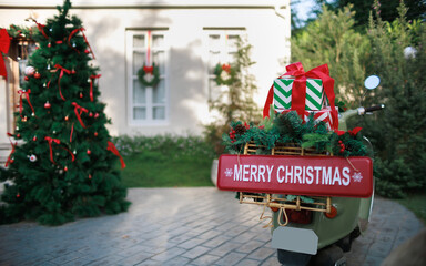 close-up, gifts with bow tie on motocycle rear of the motocycle have red sign with merry christmas text and decorate of christmas tree background