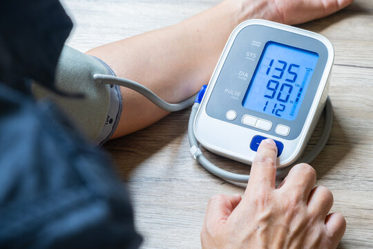 Man check blood pressure monitor and heart rate monitor with digital pressure gauge. Health care and Medical concept	
