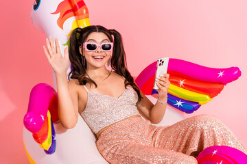 Young glam model enjoys stylish party vibe with pink sequins top rainbow wings inflatable fun and...