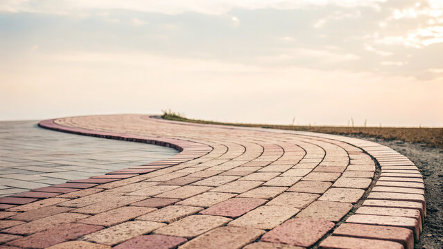 Winding path made of colorful stones in a serene outdoor landscape at sunset