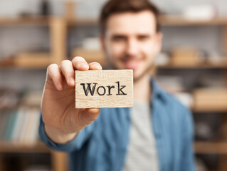 Smiling Man Holding Cube with the Word Work 