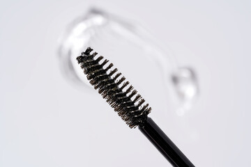 Essence serum gel stroke for eyebrows and eyelashes on a white background next to brush