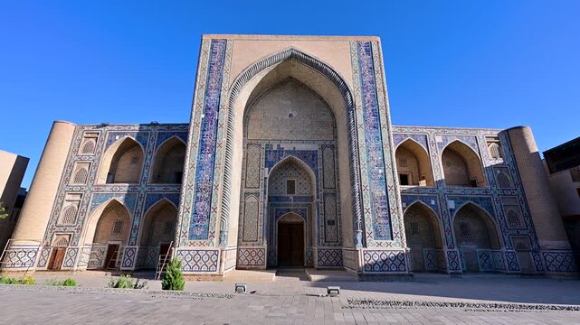 A detailed look at the Ulugh Beg Madrasa in Bukhara, Uzbekistan, showing brick patterns, tilework, and traditional Islamic architecture.
