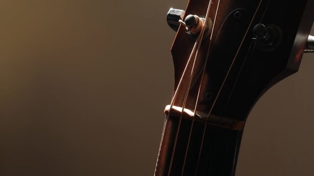 Guitar Headstock Side View: Wooden Neck with Tuning Pegs and Strings Close-up on Classic Acoustic Musical Instrument