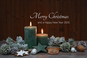 Burning candles, Christmas baubles, and fir branches are arranged in front of a wooden board. The greeting "Merry Christmas and a Happy New Year" is written on the wood.