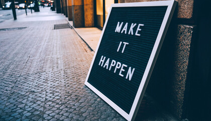 Obraz premium “Make It Happen” letter board sign on city street – motivation and entrepreneurship concept