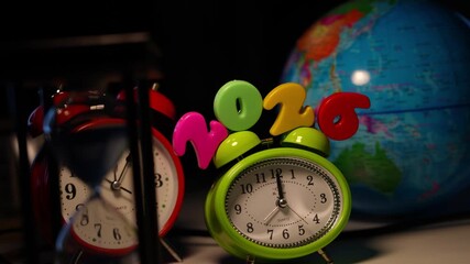 Colorful alarm clocks with globe background, Close-up of colorful alarm clocks, with a globe in the background, symbolizing time and travel - Powered by Adobe