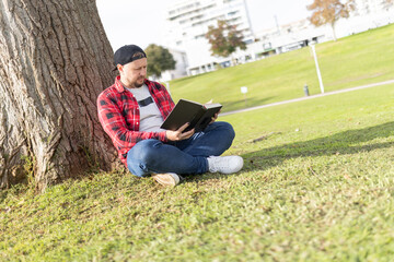 Fototapeta premium Man reading book enjoying quiet time in park