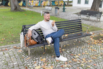 Man enjoying healthy healthy snack on autumn park bench