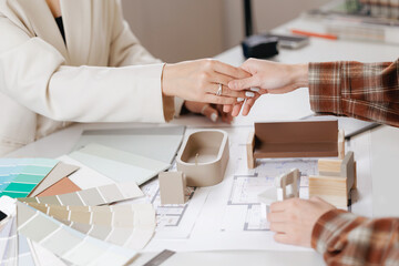 Agreement between client and designer. Collaborative discussion between women on architectural design concepts