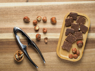 walnuts and hazelnuts, chocolate with nuts, nutcracker, background, Christmas wallpaper on a wooden countertop