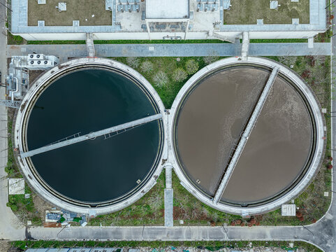Aerial view of round wastewater treatment tanks with rotating bridges.