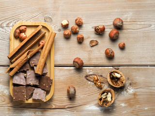 walnuts and hazelnuts, cinnamon, chocolate with nuts, background, Christmas wallpaper on a wooden countertop