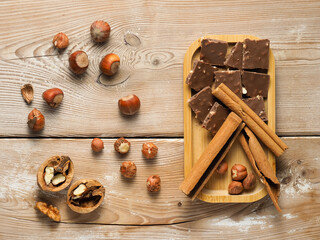 walnuts and hazelnuts, cinnamon, chocolate with nuts, background, Christmas wallpaper on a wooden countertop