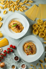 Two bowls of spaghetti bolognese with fresh ingredients