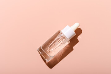 A transparent bottle of serum in pink background ,  Clear glass dropper bottle with serum on soft pink background, showcasing skincare product and elegant design for beaut