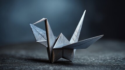 Close up of a metallic origami paper crane bird against dark background